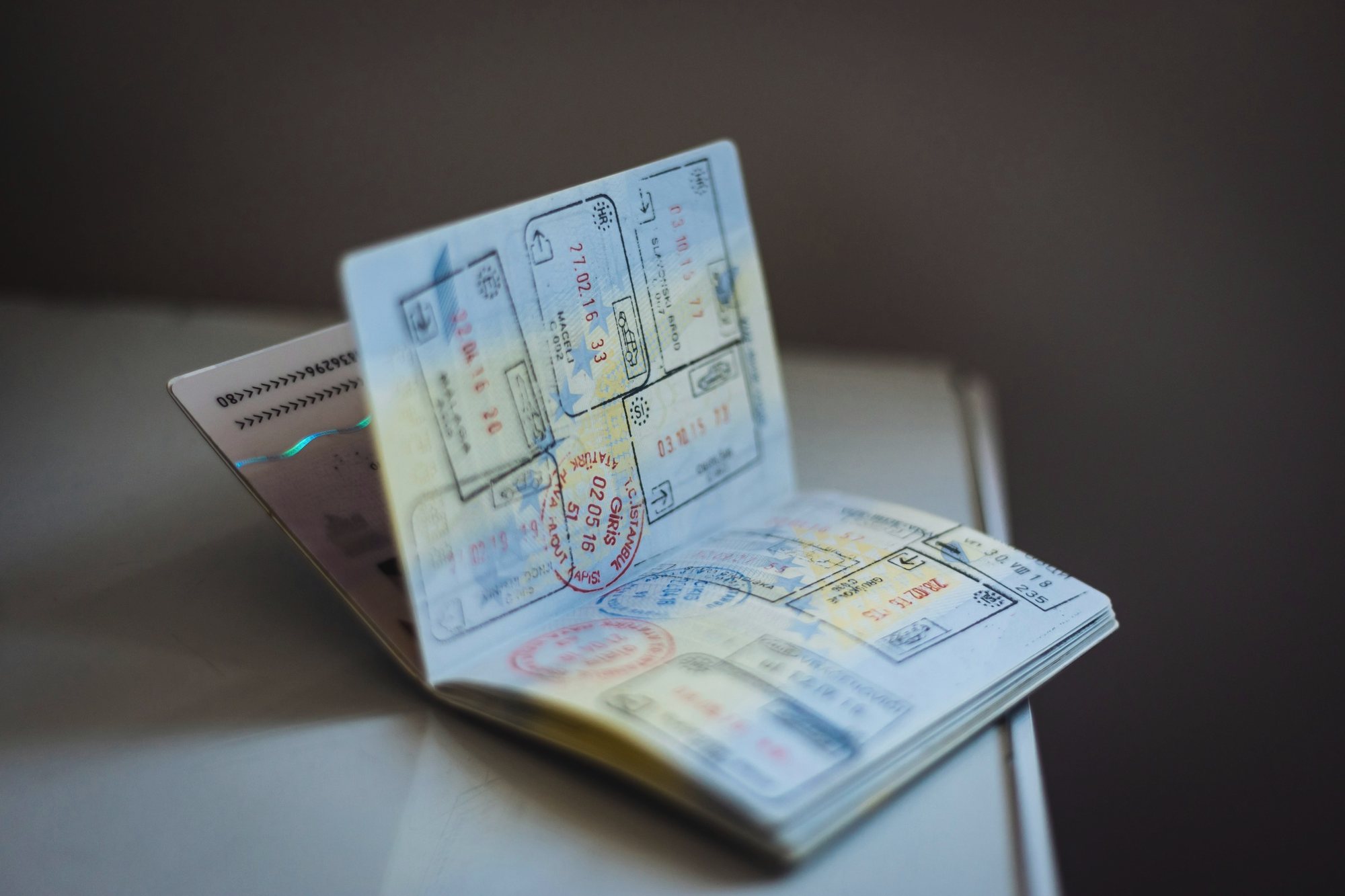 Open passport with visa stamps on a desk