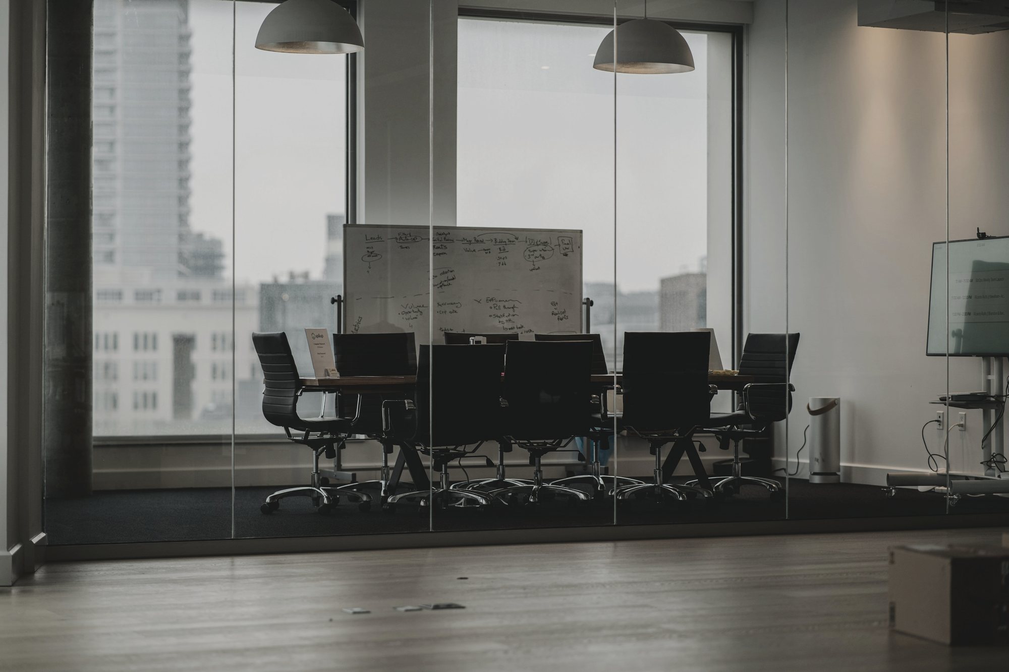 A meeting behind a glass wall overlooking the city